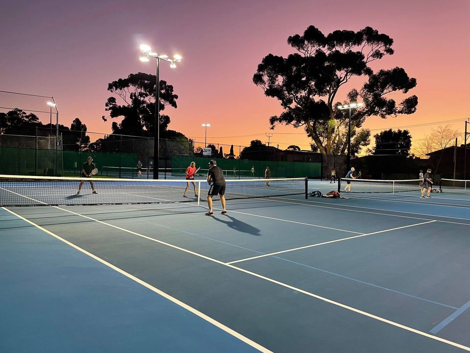 EAP tennis courts with the sun setting behind the trees